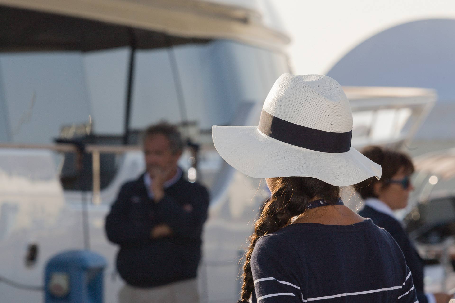 woman with white hat on board yacht with crew